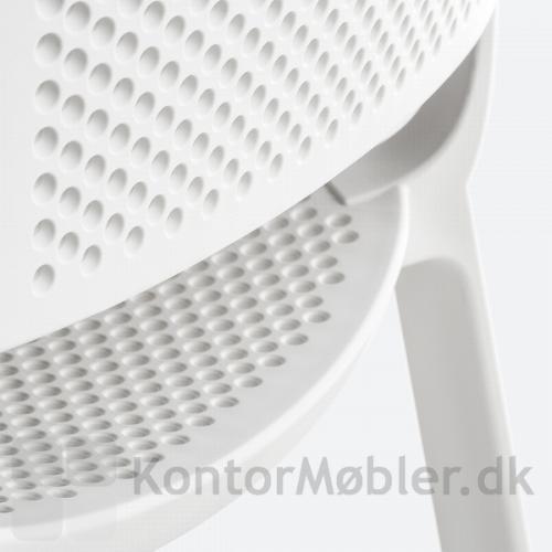 Dome stol i hvid med fokus på de hullede detaljer