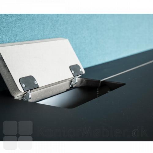 Delta bord med sort højtryks laminat bordplade og med lågeklap og slids til at gemme ledninger væk.