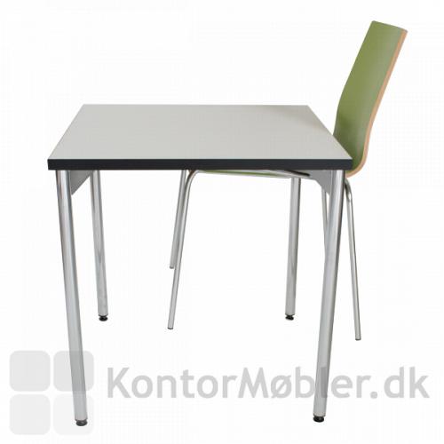 Grøn Spela stol ophængt på hvidt bord med ophængsbeslag..
