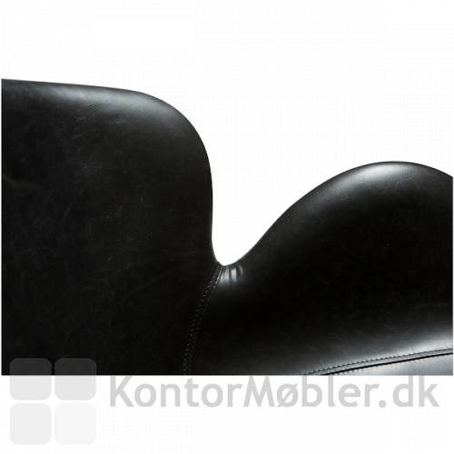 Gaia Loungestol med sort kunstlæder polstring. Stolen har lækre former og flotte synlige syninger i polstringen