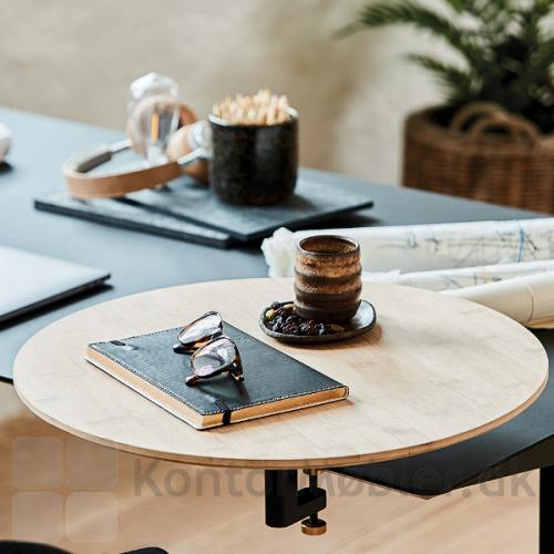 Rundt bord med bordbeslag, som giver et personligt og afgrænsende præg på det åbne kontor med mange arbejdspladser.